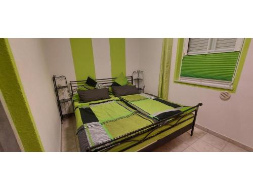 Schlafzimmer mit einem Bett mit Grün- und Weißstreifen in der Unterkunft Blue Sea Vir Apartments in Vir