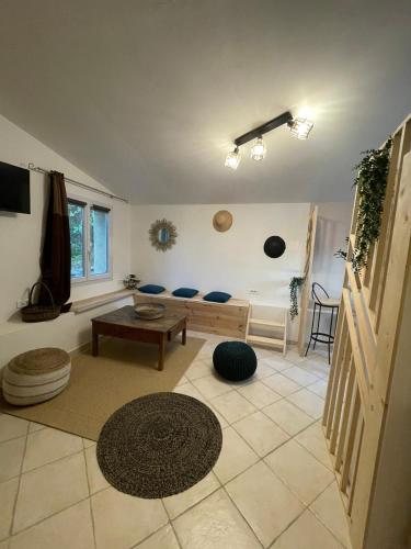 a living room with a couch and a table at L’Escapade. Entre Aix et Marseille, studio pleine nature. in Fuveau