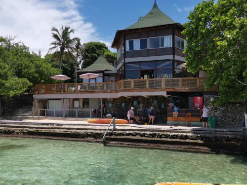 a large house with a boat in the water at Rosario EcoHotel in Isla Grande