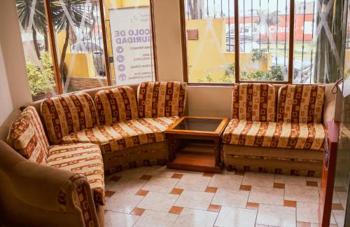 two chairs and a table in a waiting room at Hostal Siglo 21 in Tacna