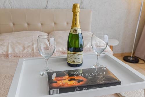 a bottle of champagne and two glasses on a table at Palanga Center Studios in Palanga