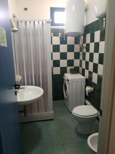 a bathroom with a toilet and a sink at La Maison Du Parc in SantʼAndrea Apostolo dello Ionio