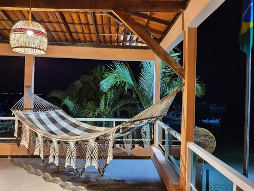 a hammock on the balcony of a house at Pousada Mar da Gamboa in Cayru