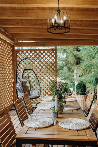 a wooden table and chairs on a wooden deck at Casa Cifu Toplita in Topliţa