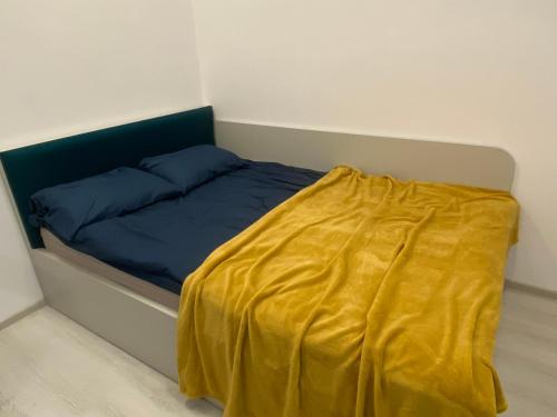 Un dormitorio con una cama con una manta amarilla. en STUDIO PALAS - the central spot, en Iaşi