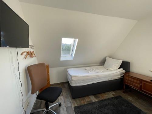 Cette petite chambre comprend un lit, un bureau et une chaise. dans l'établissement Grüner Baum, à Langenbrand