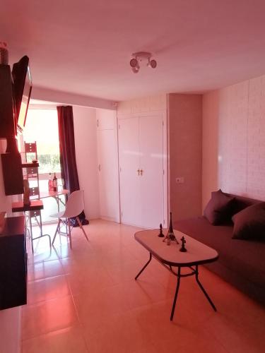 a living room with a table and a living room at Studio Petit Amour in Sitio de Calahonda