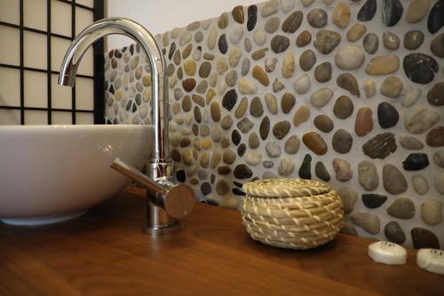La salle de bains est pourvue d'un lavabo et d'un mur en pierre. dans l'établissement Apartment Lodge 61, à Berlin