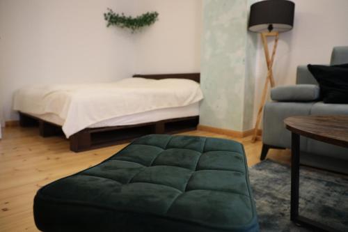 a living room with a bed and a green ottoman at Apartment Lodge 61 in Berlin