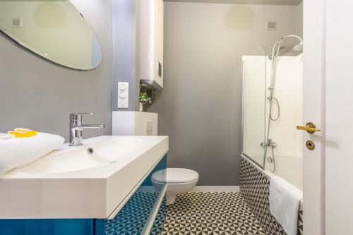 a bathroom with a sink and a toilet and a mirror at Poznanska Serviced Apartments in Warsaw