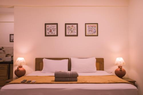 a bedroom with a bed with three pictures on the wall at Primavera Holiday Homes-FAMILY RUN GOAN GUEST HOUSE in Candolim