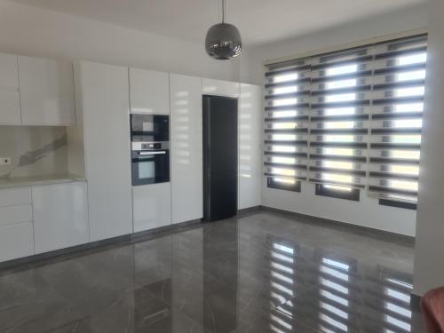 a kitchen with white walls and a large window at Eva Luxury Villa in Lachi