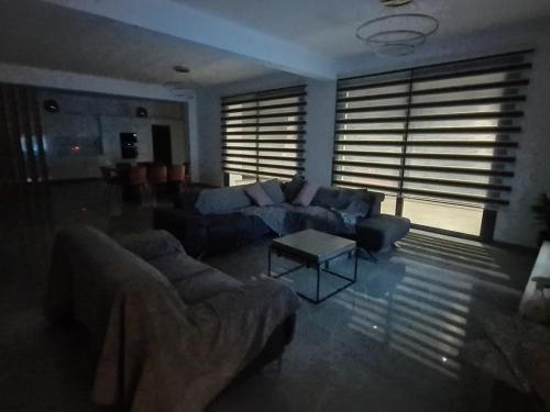 a living room with couches and a table and windows at Eva Luxury Villa in Lachi