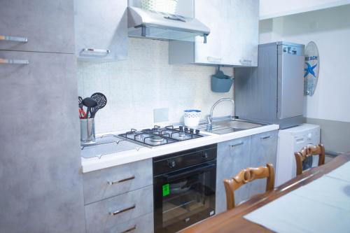 a small kitchen with a stove and a refrigerator at H11 SEA UNDER THE HOUSE - Arma di Taggia - Liguria in Taggia