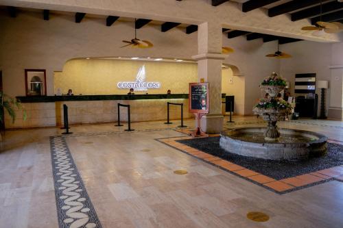 a lobby with a fountain in the middle of a building at Costa de Oro Beach Hotel in Mazatl&aacute;n