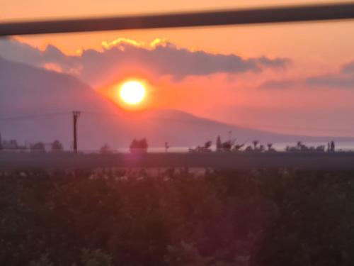 a sunset over a field with the sun setting at Eva Luxury Villa in Lachi