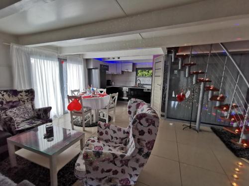 a living room with chairs and a table and a kitchen at Całoroczny dom na Mazurach WrzoSPA z jacuzzi in Stare Juchy