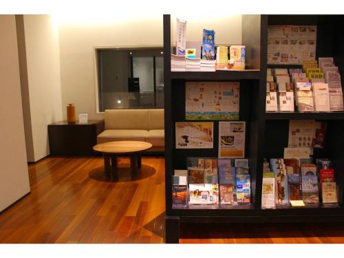 a book shelf with books and a table in a room at ＦＵＲＡＮＯ ＮＡＴＵＬＵＸ ＨＯＴＥＬ - Vacation STAY 68190v in Furano