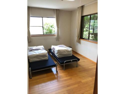 two beds in a room with two windows at Trust Maison Nishiizu - Vacation STAY 68007v in Ukusu