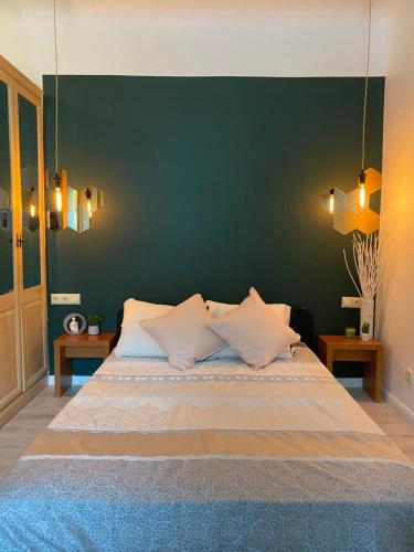 a bedroom with a large bed with a green wall at Pērles in Līgatne