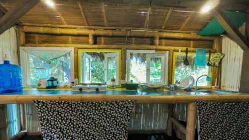 a kitchen with a counter with a sink and windows at Raices Mompiche in Mompiche