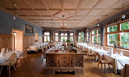 una sala da pranzo con tavoli e sedie bianchi di Hotel Ostaria Posta a San Martino in Badia