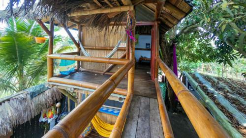 a wooden stairs leading up to a hut with a hammock at Raices Mompiche in Mompiche