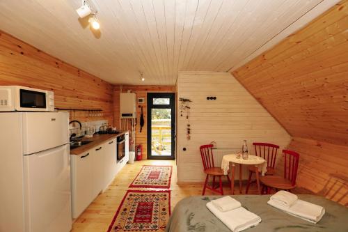 a kitchen and dining room of a log cabin at Wooden cottage "green house" in Bakuriani in Bakuriani