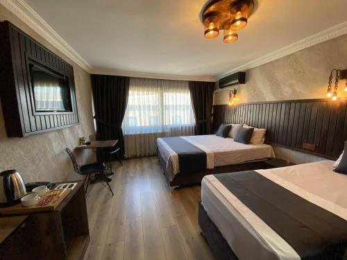 Habitación de hotel con 2 camas y escritorio en Insta Hotel Karakoy, en Estambul