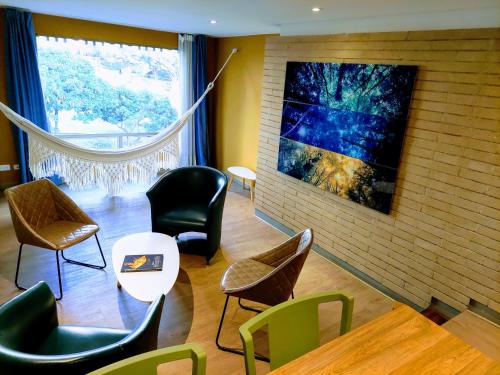 a waiting room with chairs and a painting on the wall at Hotel Viaggio Teleport City Suites in Bogotá