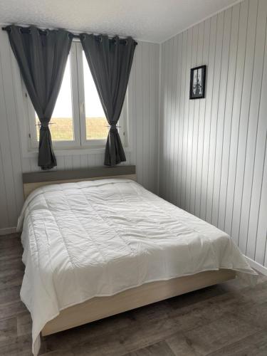 1 dormitorio con 1 cama blanca grande y ventana en L’échappée belle en Sormery