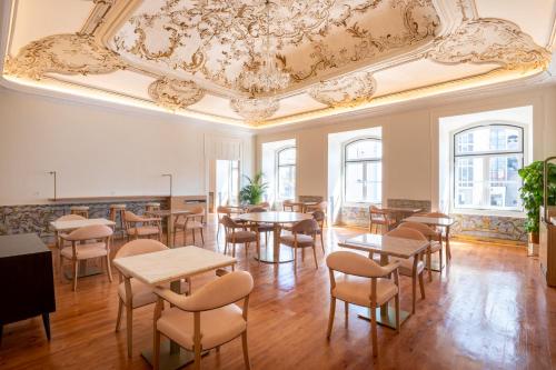 une chambre avec des tables et des chaises et un plafond dans l'établissement Memoria Lisboa FLH Hotels, à Lisbonne