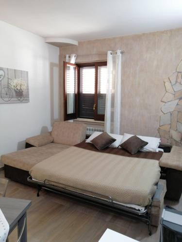 a bedroom with a bed and a couch at STONE HOUSE e Casa Vacanze Zia Rosina in Montemaggiore Belsito