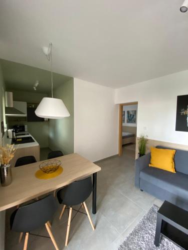 uma sala de estar com uma mesa e um sofá azul em MAXIM Apartments em Harkány