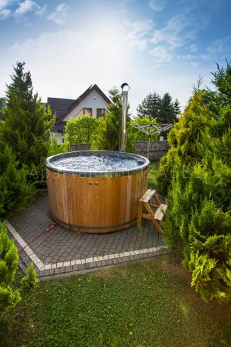 a large hot tub in a yard with trees at Apartament Izabel in Nowy Targ