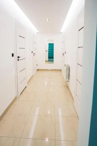 a large white room with white cabinets and a tile floor at Apartament Izabel in Nowy Targ
