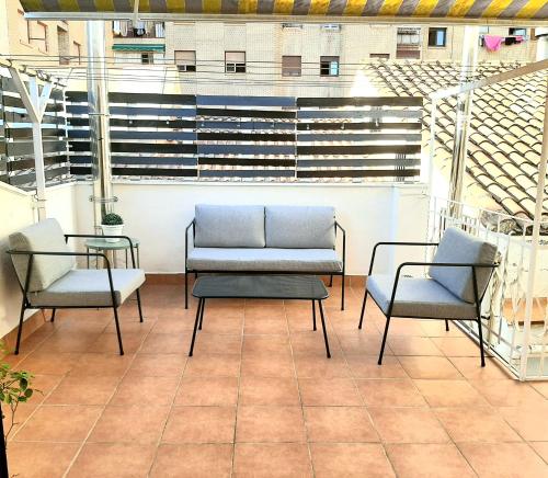モンソンにあるÁtico en Monzónのバルコニー(椅子2脚、ソファ、テーブル付)