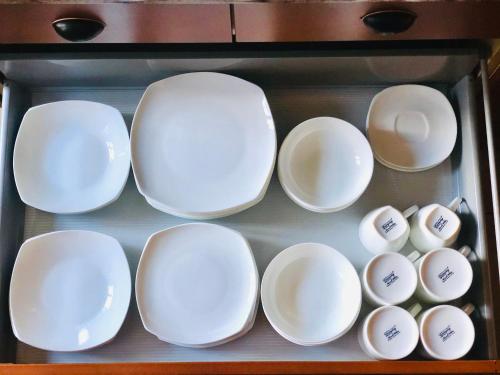 a group of white plates and bowls in a drawer at Quinta Pereirinha Farm - A Private 3 Bedroom Vacation Home, Close to Hiking w Ocean Views - Pico Island, Azores in São Roque do Pico