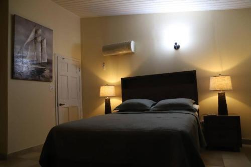 una camera da letto con un letto con due lampade sopra di A Beautiful villa in a prime location of Jolly a Jolly Harbour