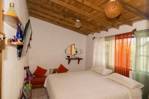 1 dormitorio con cama blanca y ventana en Ideal y linda casita en San Cristóbal-Galápagos en San Cristóbal