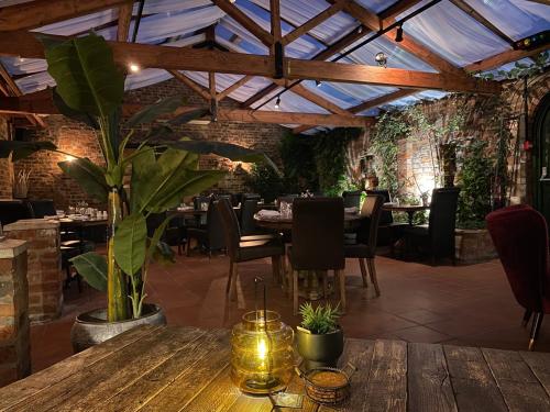 uma sala de jantar com uma mesa de madeira e uma planta em Imaginarium restaurant em Barton upon Humber