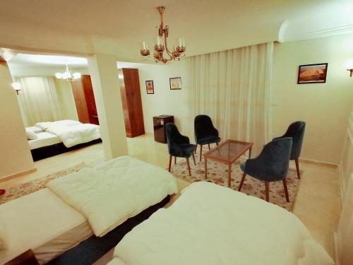 a hotel room with two beds and chairs and a table at Rihana pyramids hotel in Cairo