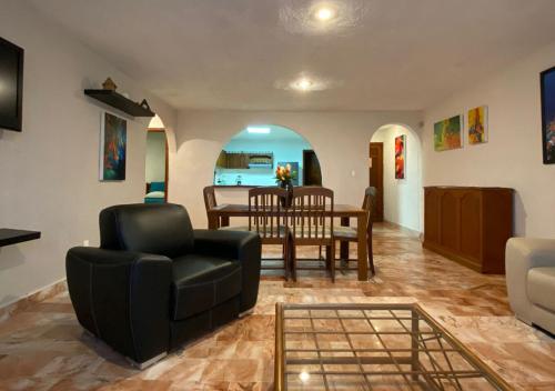 a living room with a table and chairs and a dining room at Departamento Deli in Cancún