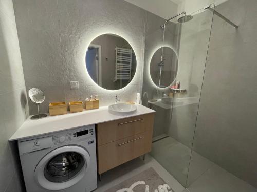 une salle de bain avec une machine à laver et un lavabo dans l'établissement Nadmorska ucieczka Niechorze - Niechorze Seaside Getaway - Rezydencja Niechorze, à Niechorze