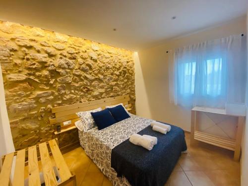 una camera con letto e parete in pietra di Casa Pastor, Delta del Ebro a El Lligallo del Gànguil