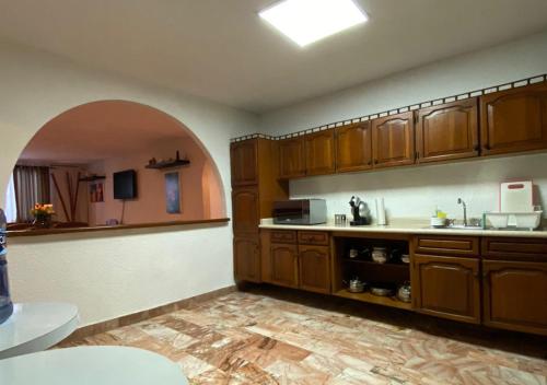 uma cozinha com armários de madeira e uma bancada em Departamento Deli em Cancún