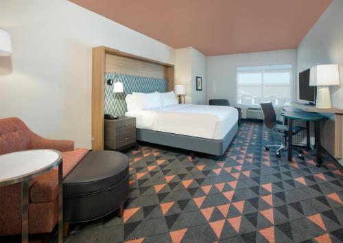 a hotel room with a bed and a desk and chair at Holiday Inn Dallas - Fort Worth Airport South by IHG in Euless