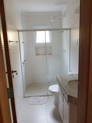 ein Bad mit einer Dusche, einem WC und einem Waschbecken in der Unterkunft Apartamento Beira-Mar, Paraíso dos Pataxós. in Porto Seguro