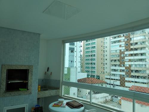 a bathroom with a sink and a large window at Apto alto padrão in Balneário Camboriú