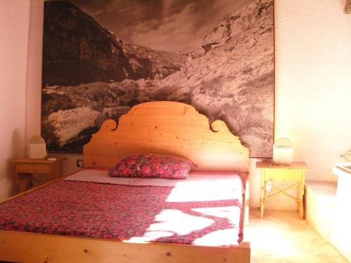 a bedroom with a bed with a painting on the wall at Limonaia in Salento in Marittima